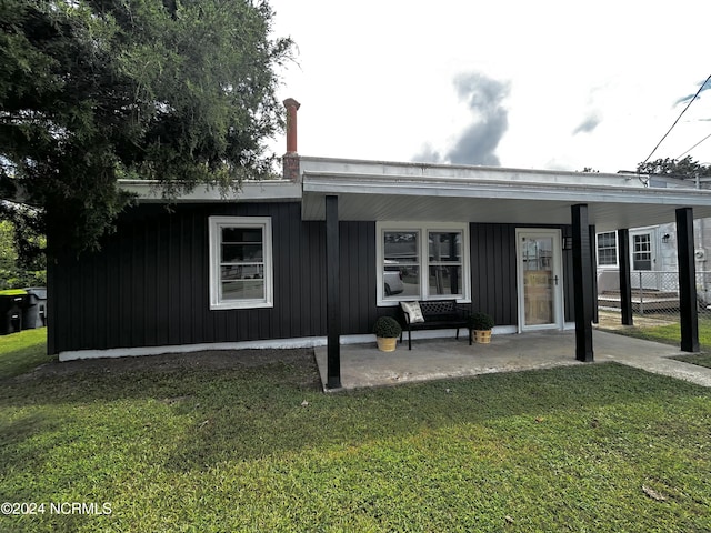 view of front of house featuring a front lawn, fence, and board and batten siding