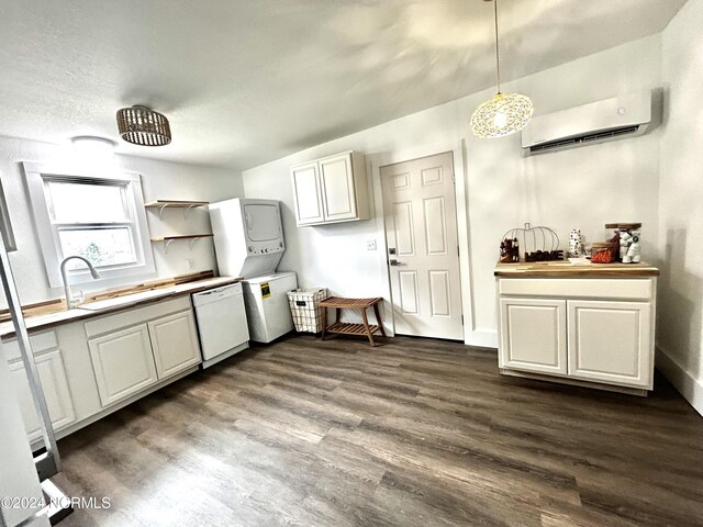 kitchen with a wall unit AC, dishwasher, stacked washer / dryer, dark hardwood / wood-style flooring, and white cabinets