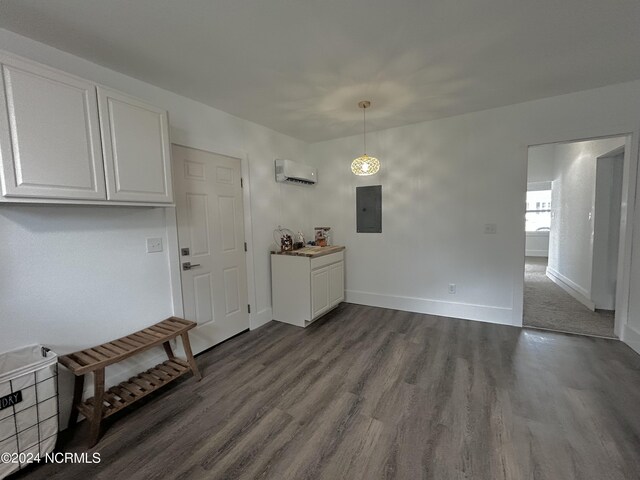 unfurnished dining area with a wall unit AC, hardwood / wood-style flooring, and electric panel