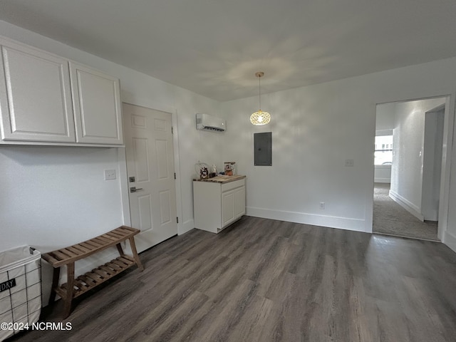 unfurnished dining area with electric panel, dark wood finished floors, baseboards, and a wall unit AC