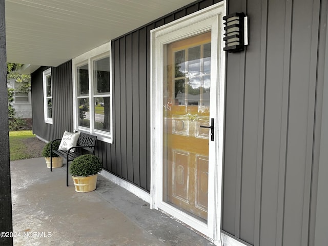 doorway to property featuring covered porch and board and batten siding