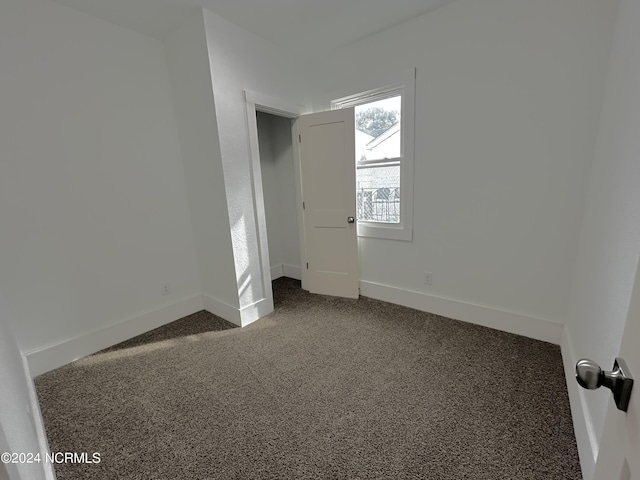 unfurnished bedroom with baseboards and carpet