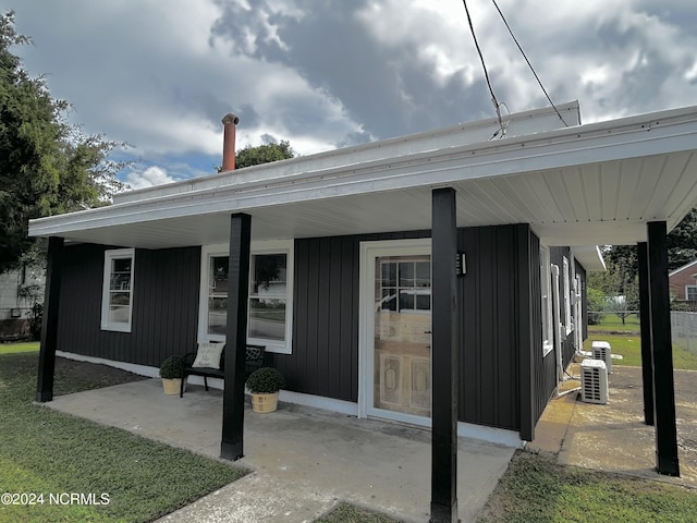 entrance to property with covered porch and central AC