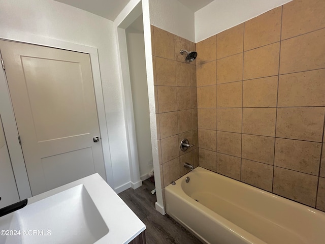 bathroom with tiled shower / bath, sink, and hardwood / wood-style floors