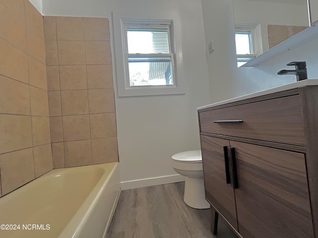 bathroom featuring toilet, plenty of natural light, hardwood / wood-style flooring, and vanity