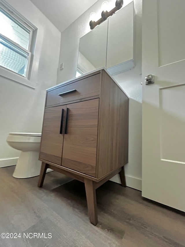 bathroom featuring baseboards, toilet, and wood finished floors