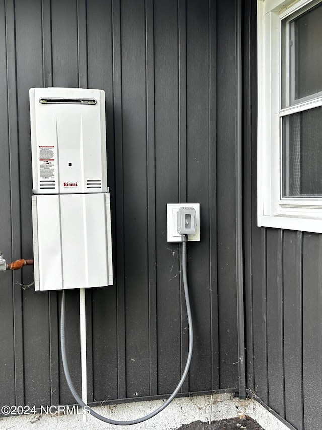 exterior details featuring board and batten siding and water heater