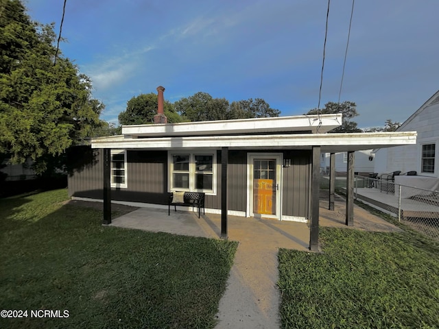 rear view of house with a lawn and a patio area