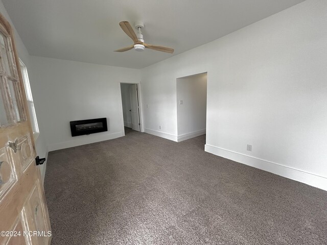 unfurnished living room featuring carpet and ceiling fan