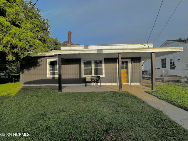 back of house featuring a patio area, a lawn, and fence