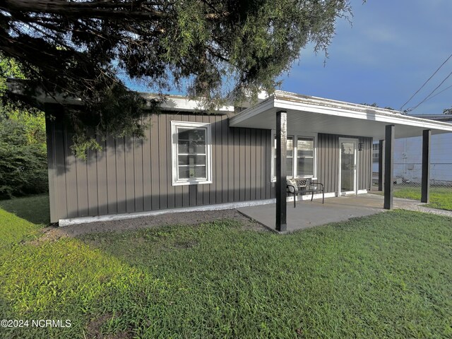 rear view of house with a patio area and a lawn