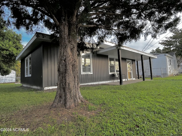 back of property with a patio area, fence, and a lawn