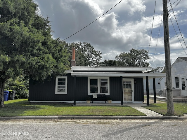 view of front of property with covered porch, board and batten siding, and a front yard