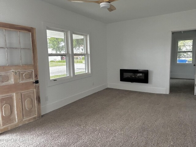 unfurnished living room featuring carpet flooring and ceiling fan