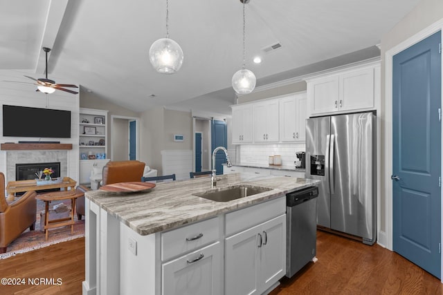 kitchen with stainless steel appliances, sink, a kitchen island with sink, and white cabinets