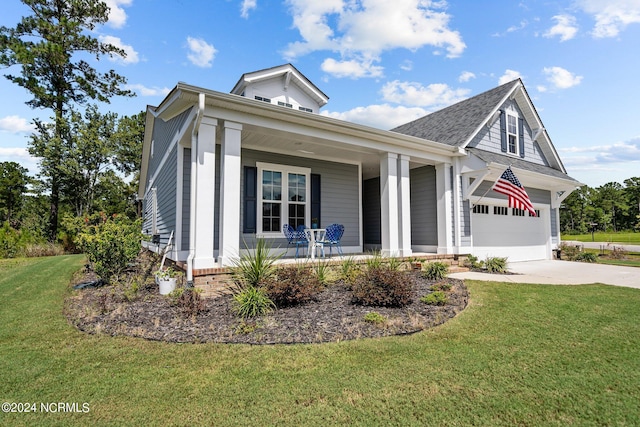 view of front of house featuring a garage, a front yard, and covered porch