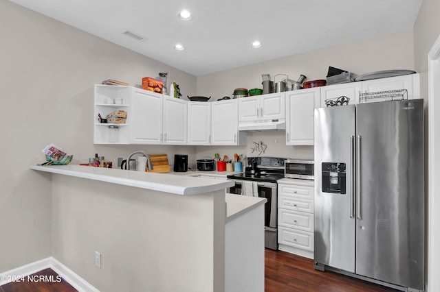 kitchen featuring white cabinets, appliances with stainless steel finishes, kitchen peninsula, and dark hardwood / wood-style flooring