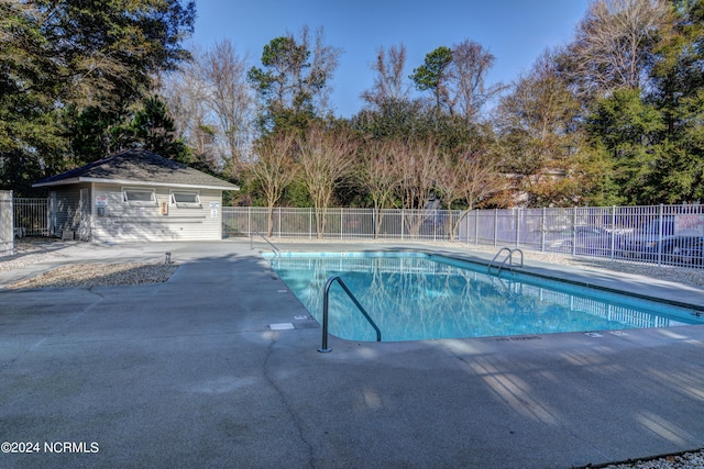 view of pool featuring a patio and an outbuilding