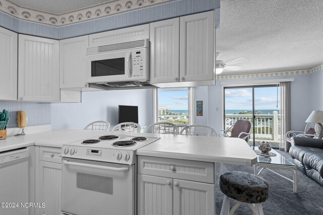 kitchen featuring white cabinetry, ceiling fan, a textured ceiling, and white appliances