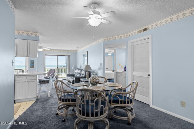 dining space featuring ornamental molding, a textured ceiling, light colored carpet, and ceiling fan