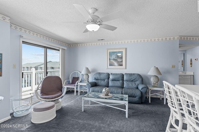 living room featuring a textured ceiling, carpet, and ceiling fan