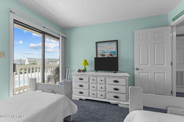 carpeted bedroom featuring access to exterior and a textured ceiling