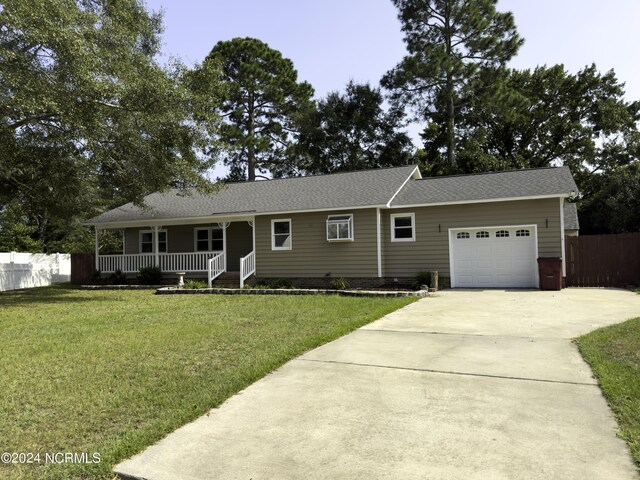 single story home featuring a front yard, a garage, and a porch