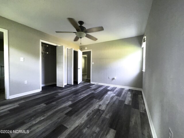 unfurnished bedroom featuring ceiling fan and dark hardwood / wood-style floors