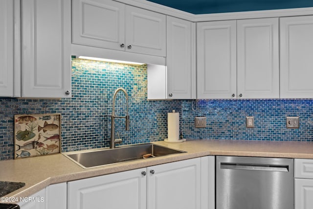 kitchen featuring tasteful backsplash, sink, stainless steel dishwasher, and white cabinets