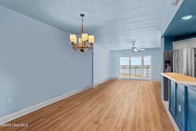 interior space featuring light hardwood / wood-style flooring and ceiling fan with notable chandelier