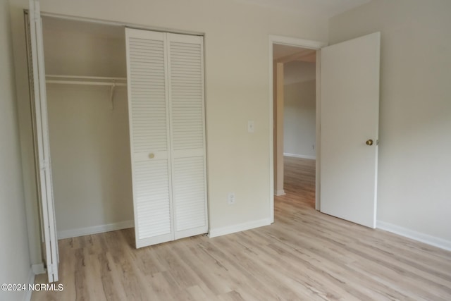 unfurnished bedroom with a closet and light hardwood / wood-style floors