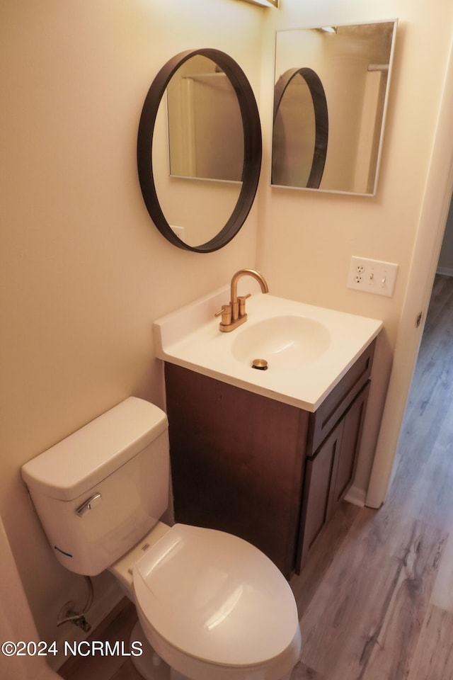 bathroom featuring toilet, hardwood / wood-style flooring, and vanity