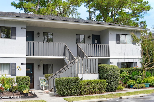 view of building exterior featuring uncovered parking and stairway