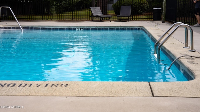 community pool with fence and a patio