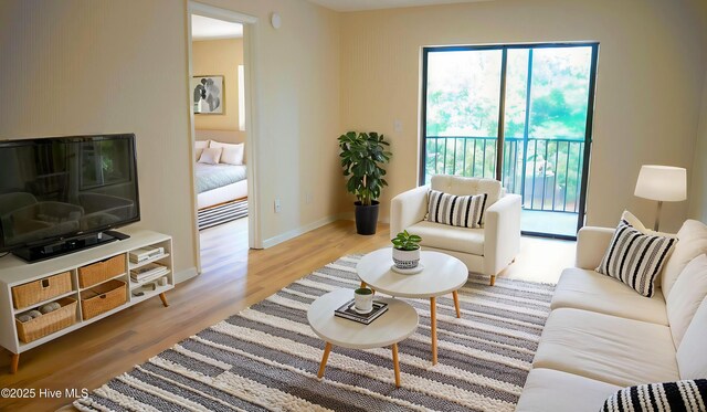 living area featuring light wood-type flooring and baseboards