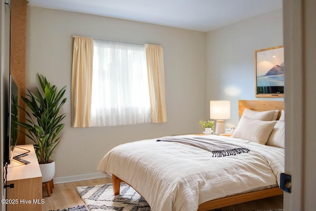 bedroom with light wood-style flooring and baseboards