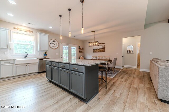 kitchen featuring a kitchen island, white cabinetry, hanging light fixtures, and a kitchen breakfast bar