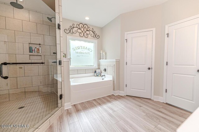 bathroom featuring hardwood / wood-style flooring and shower with separate bathtub