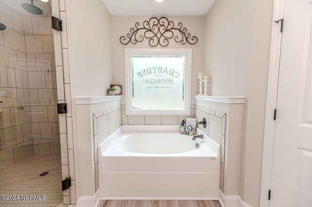 bathroom with wood-type flooring and independent shower and bath