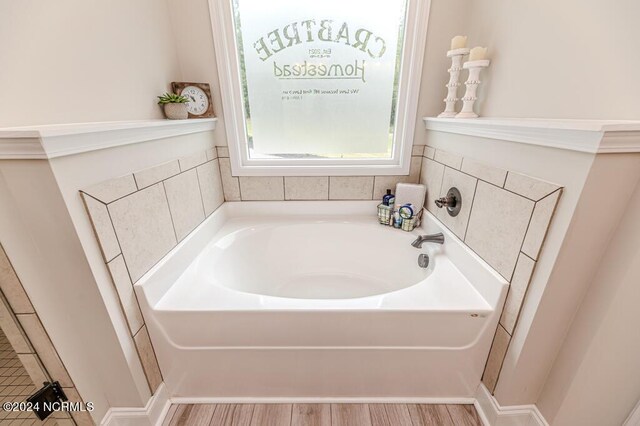 bathroom featuring wood-type flooring and a washtub