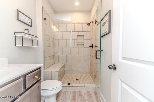 bathroom featuring an enclosed shower, vanity, and toilet