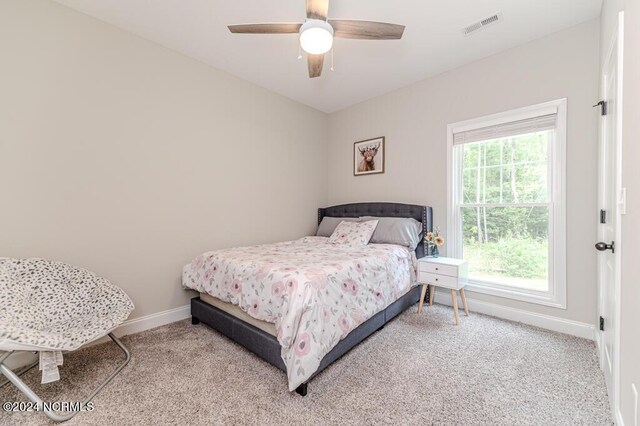 carpeted bedroom featuring ceiling fan and multiple windows