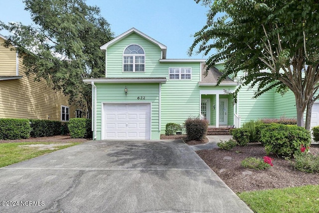 traditional-style home featuring a garage and driveway