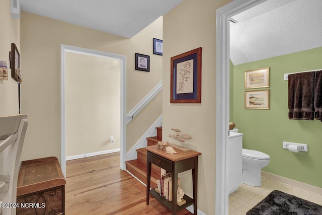 bathroom featuring vaulted ceiling, wood finished floors, toilet, and baseboards