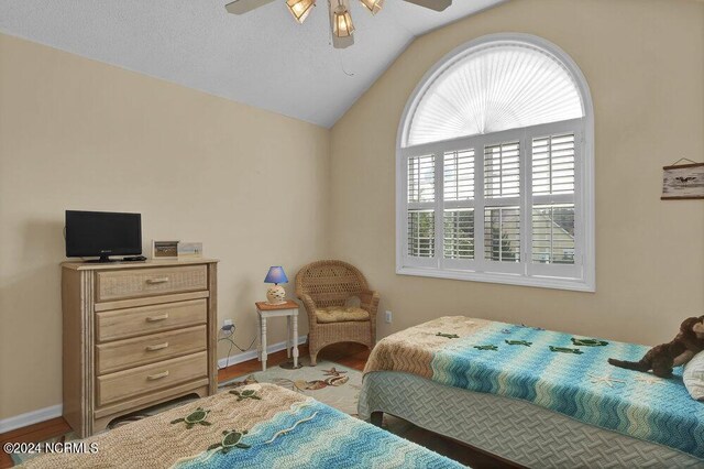 bedroom featuring vaulted ceiling, hardwood / wood-style floors, and multiple windows