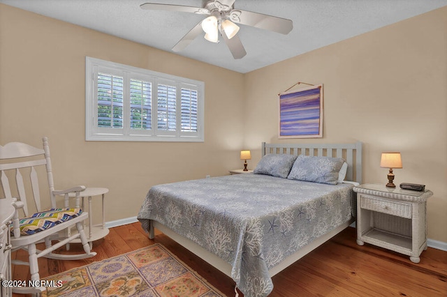 bedroom featuring a textured ceiling, ceiling fan, and dark hardwood / wood-style flooring