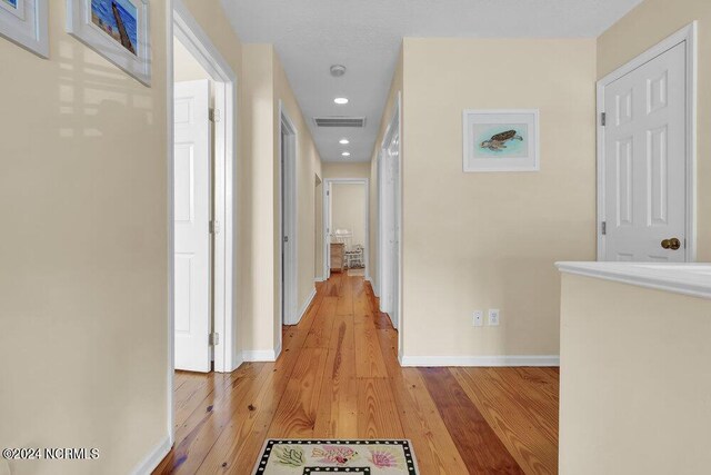 hallway with light hardwood / wood-style floors