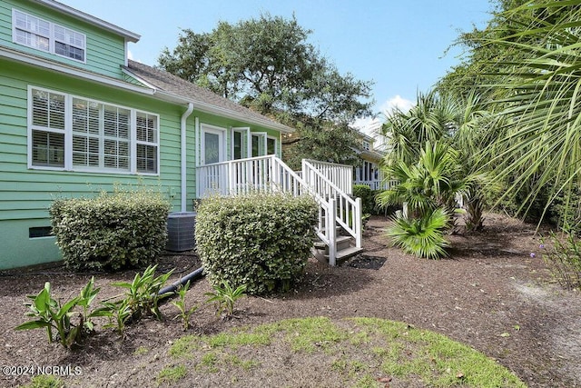 exterior space with central AC and roof with shingles