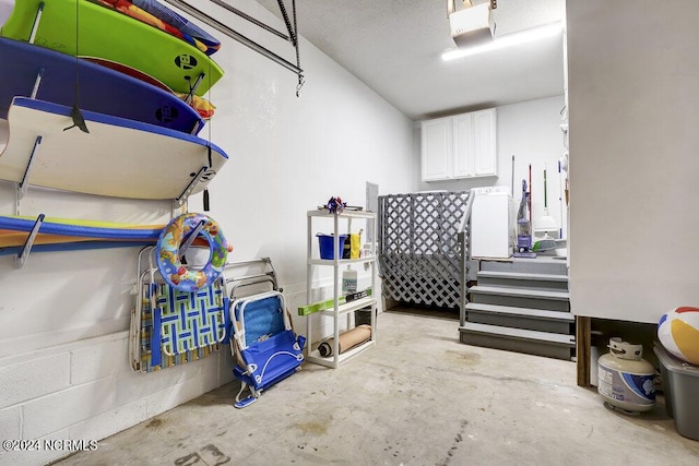 garage with concrete block wall and a garage door opener