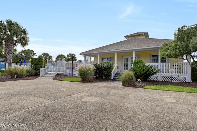 view of front facade featuring a porch, fence, and a gate